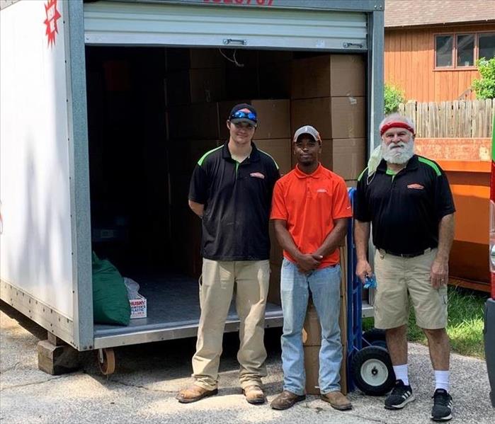 3 SERVPRO employees stand in front of a mobile storage pod.