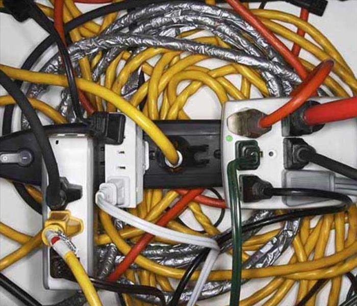 An outlet is overloaded with cords plugged in